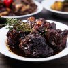 Close-up of tender braised oxtail with herbs, perfect for a gourmet dinner.